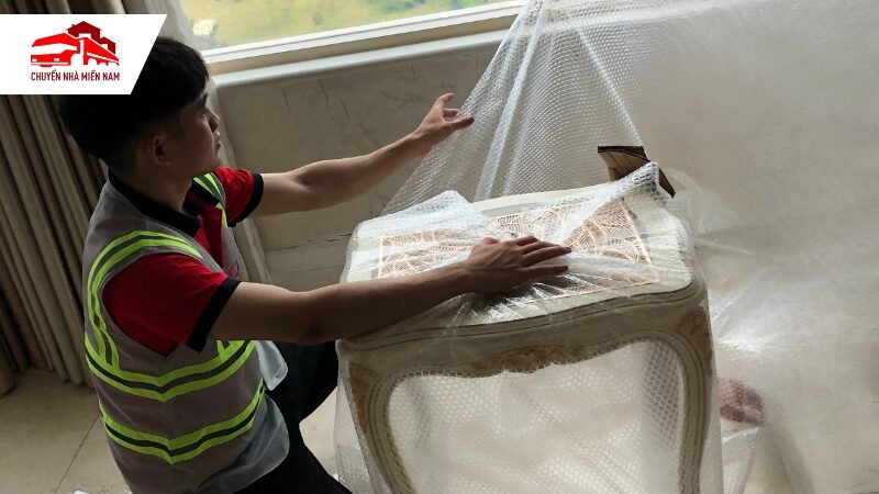 Nhân viên bọc kỹ càng bàn ghế trước khi vận chuyển