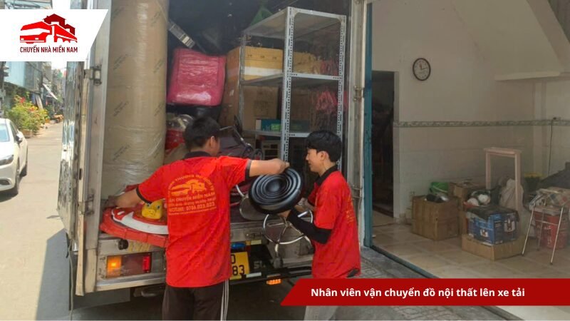 Nhân viên vận chuyển đồ nội thất lên xe tải