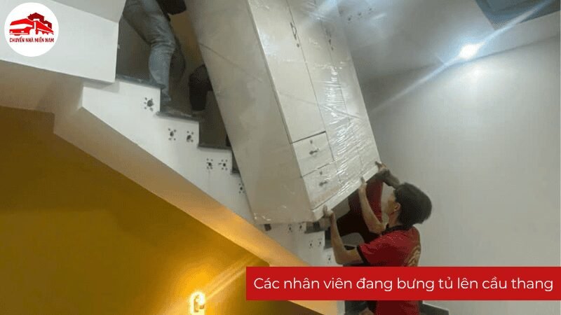 Các nhân viên Chuyển Nhà Miền Nam đang bưng tủ lên cầu thang